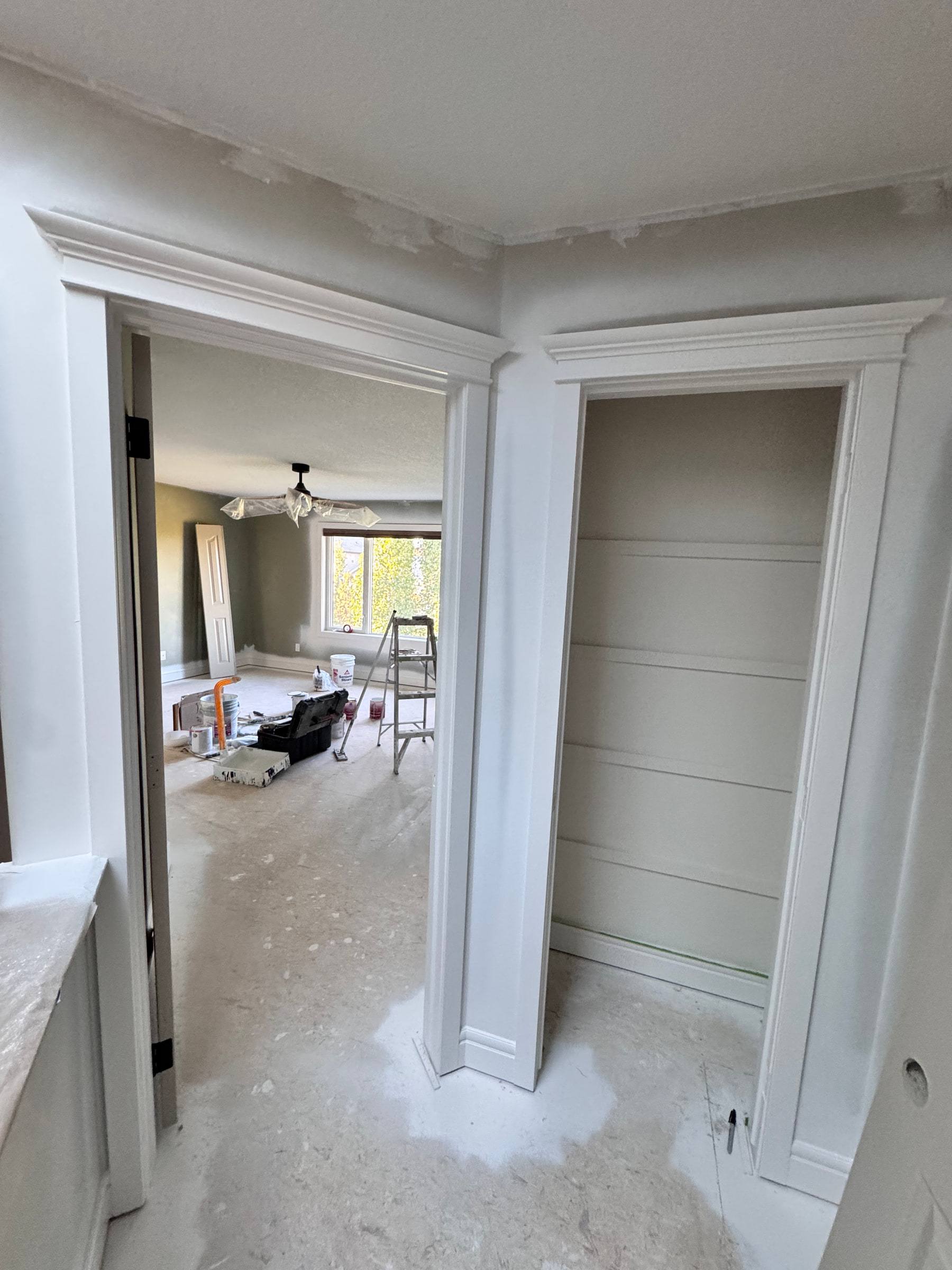 Closet opening trimmed with a new white casing, header and matching baseboard
