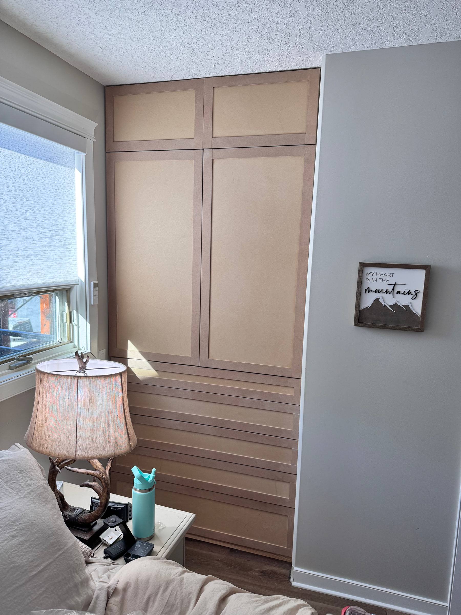 The same wardrobe installed in raw MDF before spraying, with doors and drawer fronts fitted