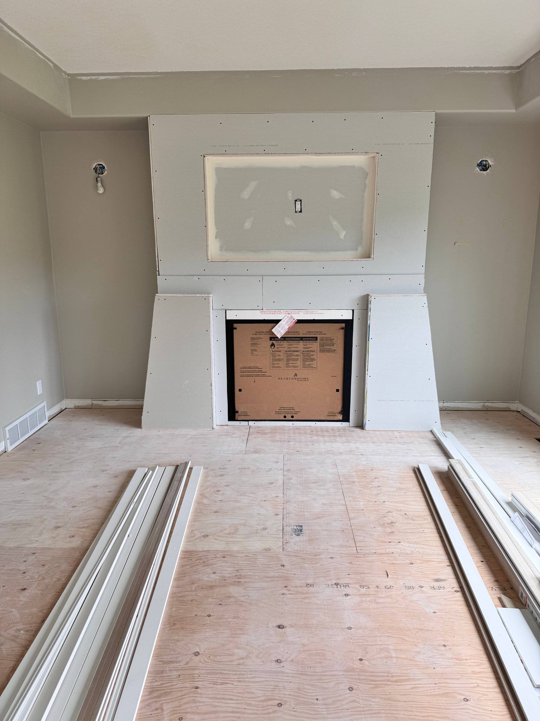The same fireplace bump-out boarded and taped, with a recess framed for the TV