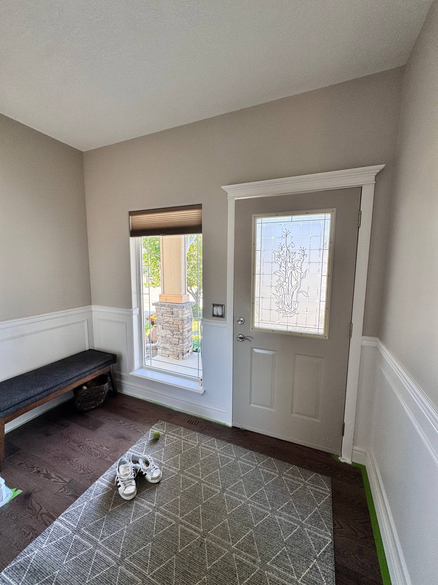Entry with chair rail wainscoting wrapping around the front door and side window